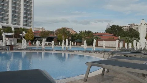 Slow pan across empty sun loungers and pool Stock Footage 106498984
