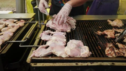 Slow pan across large open flame grills cooking chicken Stock Footage 239121976