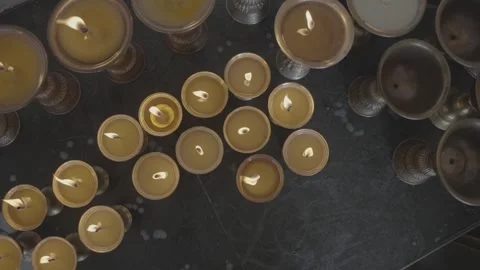 Slow Pan Across Lit Tibetan Butter Lamps Glowing on Buddhist Altar Stock Footage 345632007