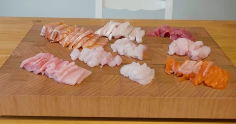 Slow pan around a beautiful presentation of fresh sliced sashimi fish on a board Stock-Footage 115545203