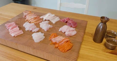 Slow pan around a beautiful presentation of fresh sliced sashimi fish on a board Video stock 115545334