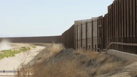Slow Pan of Border Fence Between the US and Mexico Stock Footage 60407444