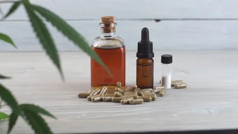 Slow pan from Cannabis leaf to Cannabis oil bottles, CBD Crystals and CBD pil Stock Footage 107072061
