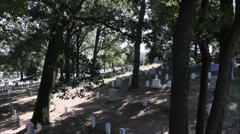 Slow pan of a cemetery during the day with sunshine and trees Stock Footage 41197657