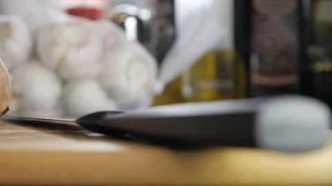 Slow pan close up onion and knife on cutting board low angle Stock Footage 102802492