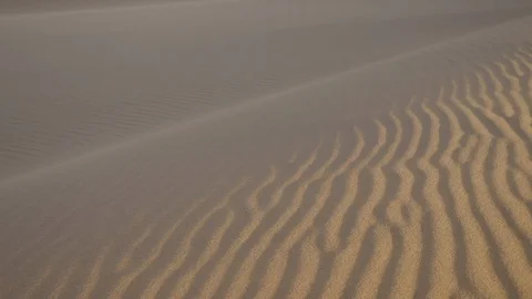 Slow pan close up of wind blowing across desert sand dune patterned texture Stock Footage 103673052