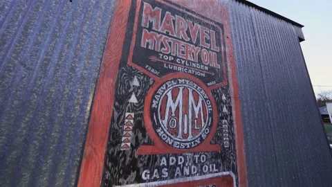 Slow pan down revealing antique Mystery Motor Oil sign on the side of a barn Stock Footage 147738331