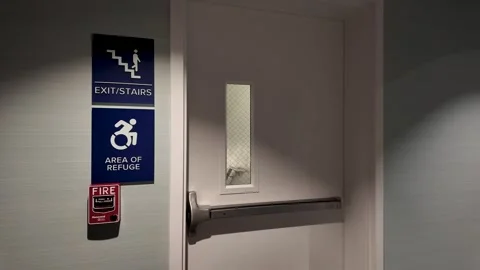 Slow Pan of Empty Hotel Corridor from Emergency Exit Sign Stock Footage 325419781