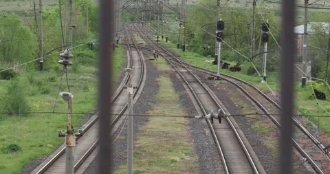 Slow Pan of Empty Railway Tracks with Red Signal Behind Fence Video stock 336722687