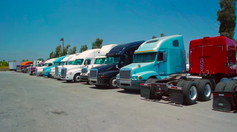 Slow pan of freight liner trucks parked in an outdoor lot 스톡 동영상 60030877