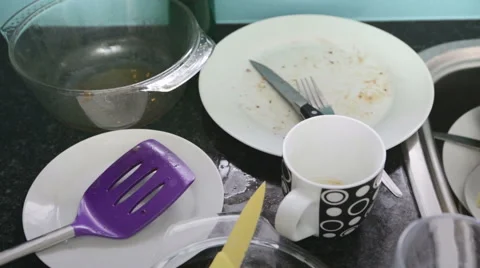 Slow pan, high angle view of dirty dishes piled up in kitchen sink Stock Footage 54695873