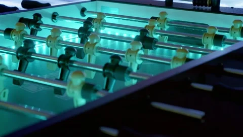 Slow pan of an led-backlit foosball table.  The futuristic setting is Stock Footage 229932939
