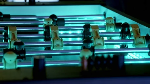 Slow pan of an led-backlit foosball table.  The ball flies back and forth Stock Footage 229932952
