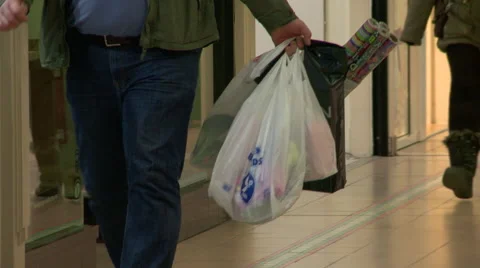 Slow Pan Left of a Man Walking Through a Shopping Centre Stock Footage 61608924