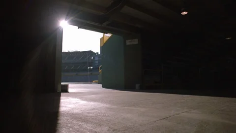 Slow pan left to right of stadium seen through an open door on a sunny day Stock Footage 104771420