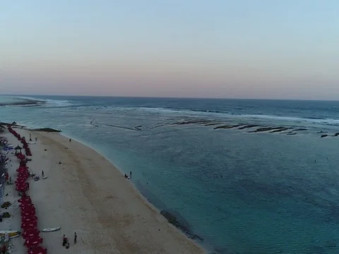 Slow pan over beach and ocean at sunset in Bali, Indonesia. Stock Footage 80190224