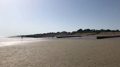 Slow pan over beach with sun glistening on the distant sea. Stock Footage 111513592