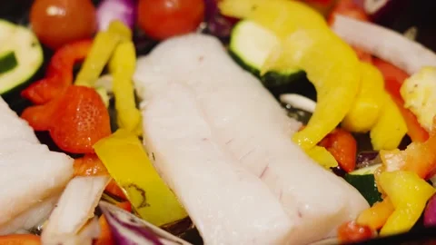 Slow pan over traybake of wild caught atlantic Cod fillets with mediterranean Stock Footage 328655259