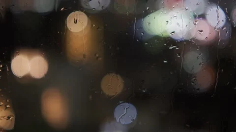 Slow pan of a rainy window at night with bokeh city lights in the background Stock Footage 157666221