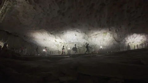 Slow pan right people explore cave at ha long bay Stock Footage 287210637