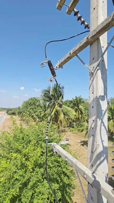 Slow pan right video of open drop out fuse cutout hanging on concrete power. Video stock 328519780