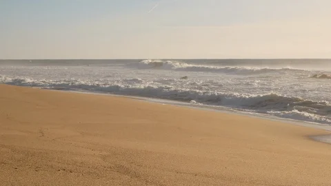 Slow pan up on sandy beach on a misty morning from sand to ocean waves 스톡 동영상 103284823