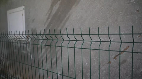 Slow pan shot, green, bordered wire fence Stock Footage 343965308