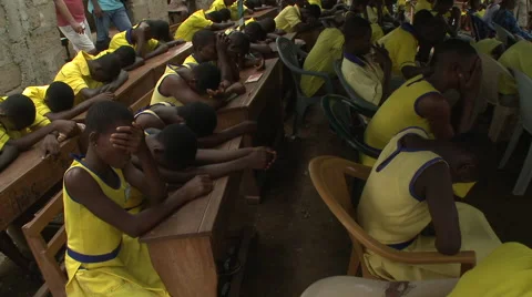 SLOW PAN: STUDENTS PRAYING AT SCHOOL ASSEMBLY Stock Footage 60115462