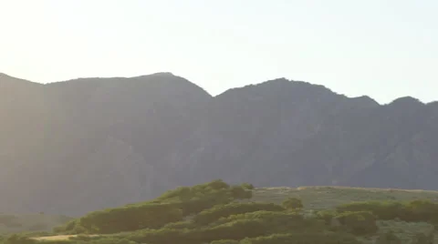 Slow Pan of Sun Shining Behind Moutains at Sunset 動画素材 68723659