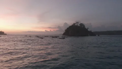 Slow pan up towards small island off the coast of Nusa Penida, Bali during sunse Stock Footage 223263984