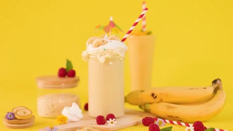A slow pan video of a refreshing banana milkshake with whipped cream and sp.. Stock Footage 333697165