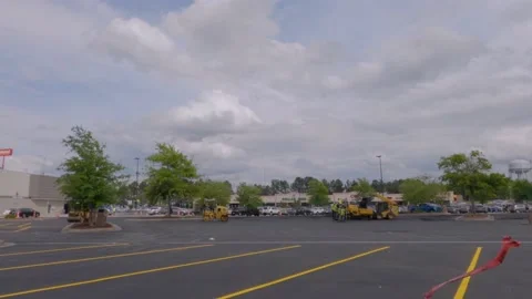 Slow pan of a Walmart super center parking lot paving crew and industrial equ Stock Footage 153563270