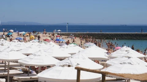 Slow panning of crowded Tamariz Beach in Estoril, Portugal Stock Footage 112881142