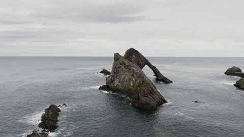 Slow panning drone shot of Bow Fiddle Rock natural sea arch in Scotland Stock Footage 334814838