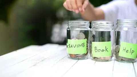Slow panning from left to right Boy saving coin in can Stock Footage 80295687