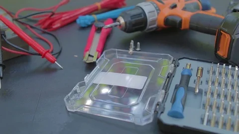 Slow panorama of instruments - multimeter, knife, screw gun, screwdriver set. Video stock 76942188