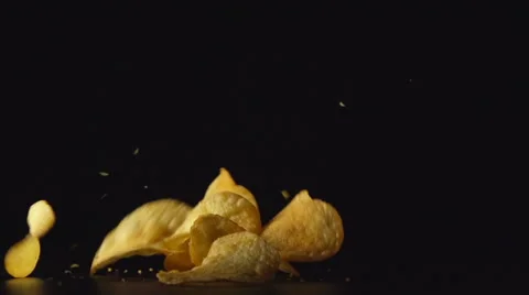 SLOW: Potato chips fall on a table. Black background Vídeo Stock 62197088