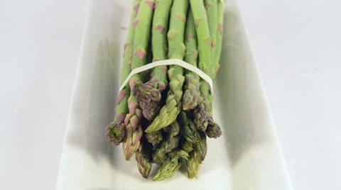 Slow pull back over a bunch of asparagus over a white plate Stock Footage 36157179