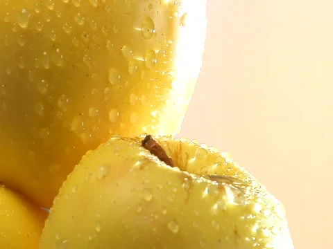 Slow pull back from stack of rotating yellow apples Stock Footage 46371523