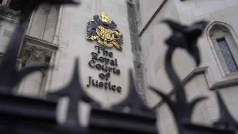 Slow Pull Focus from Royal Courts of Justice Crest to Ornate Spiked Fence Stock Footage 286134776