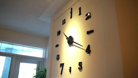 SLOW PULLBACK FROM OVERSIZED WALL CLOCK IN WARMLY LIT HOME INTERIOR Stock Footage 346514952