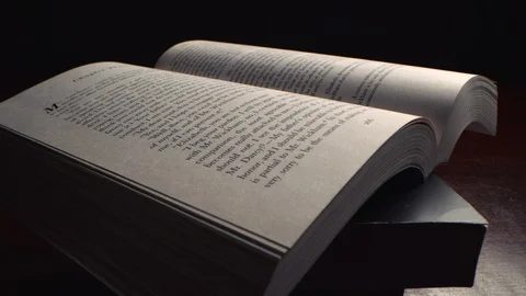 Slow push in across the surface of an open book at an angle with probe lens Видео 122605122