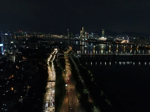 Slow push forward over city traffic and toward a bridge in Seoul at night Stock Footage 78126594