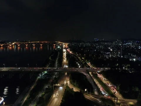 Slow push forward over city traffic and toward a bridge in Seoul at night Stock Footage 78128754