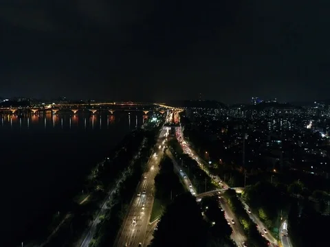 Slow push forward over city traffic and toward a bridge in Seoul at night. Stock Footage 78128840