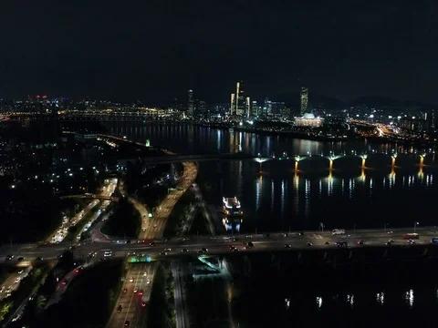 Slow push forward over city traffic and toward a bridge in Seoul at night Stock Footage 78150063