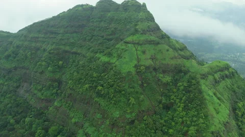 Slow push-in on high lush mountain summit shrouded in thick rain clouds Stock Footage 346173697