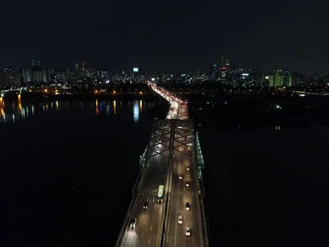 Slow push over a bridge and toward tall buildings at night in Seoul Stock Footage 78127703