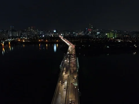 Slow push over a bridge and traffic, toward tall buildings at night in Seoul Stock Footage 78127780
