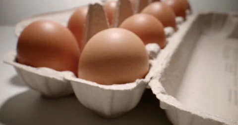 Slow Push-In Over a Cardboard Egg Carton with Fresh Eggs Stock Footage 345589903